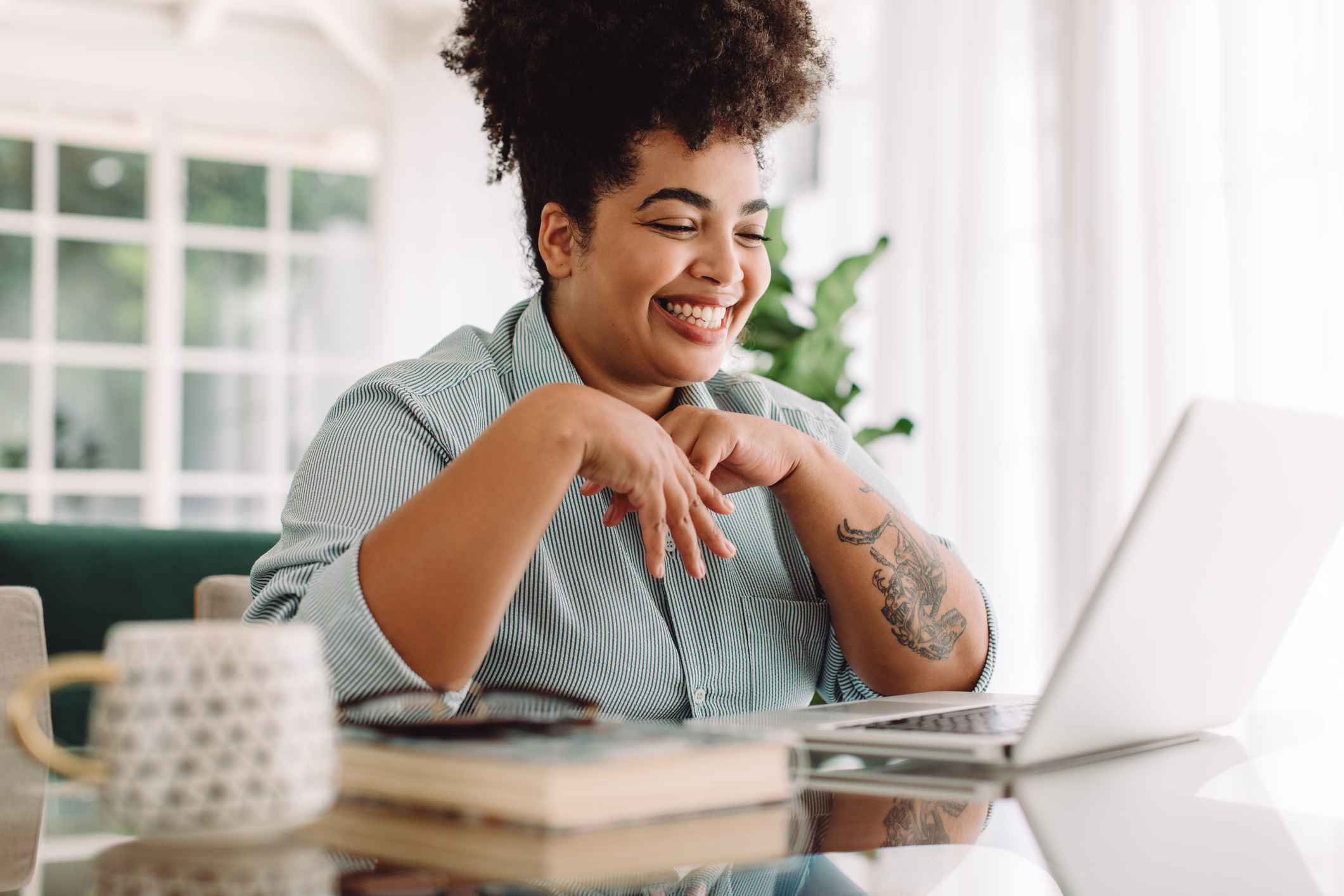 Businesswoman teleconferencing on laptop while working from home.