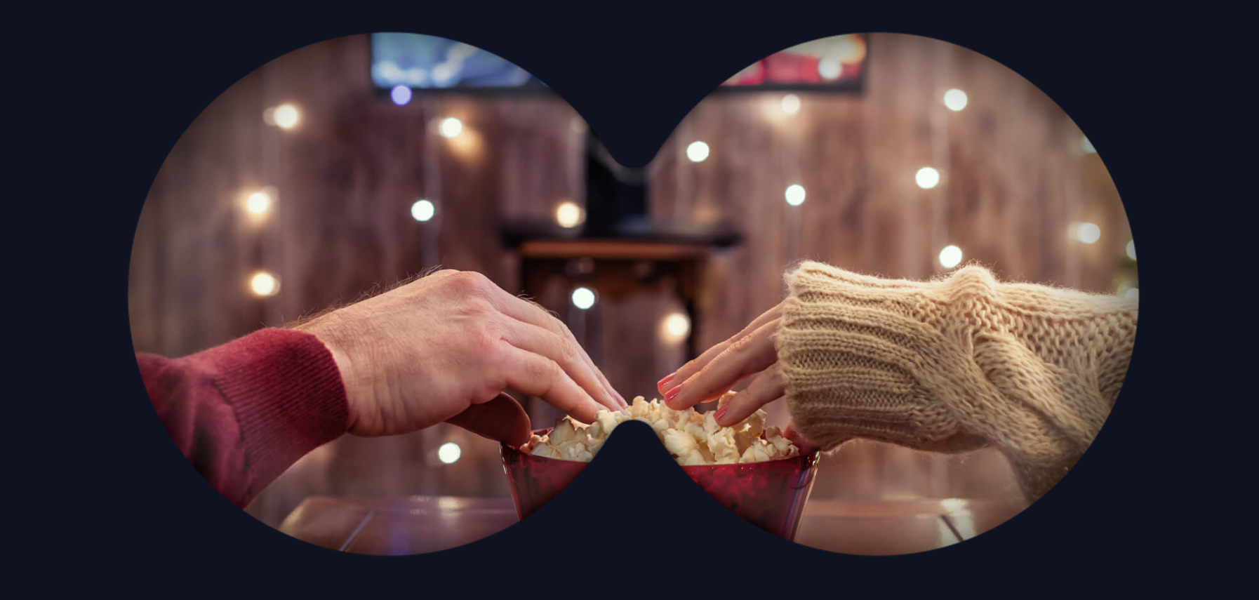 Hands taking popcorn in front of TV through a binocular overlay