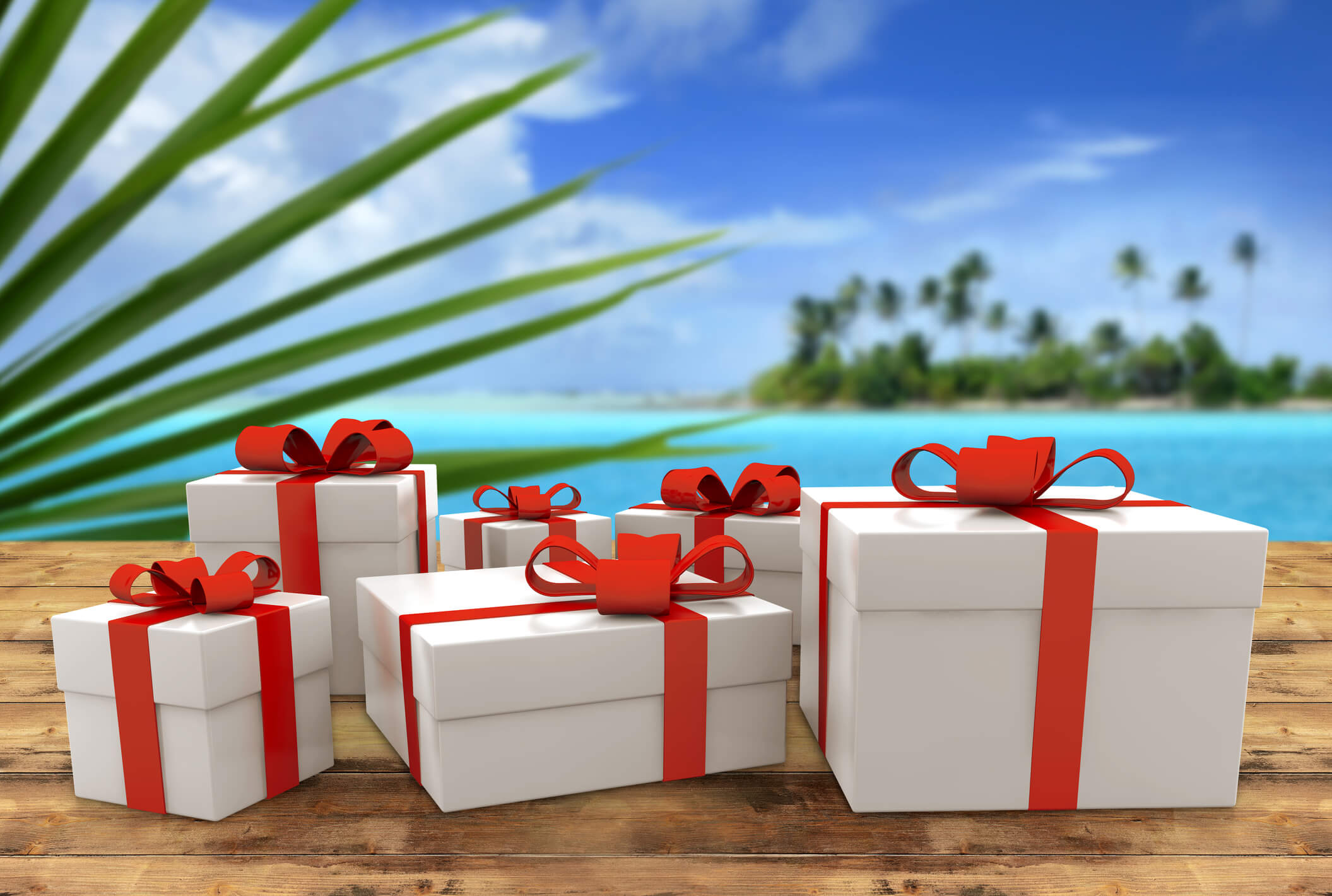 Gift packages with bows, sitting on a table at the beach.