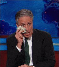 A GIF of Jon Stewart wiping away fake tears with a $100 bill.