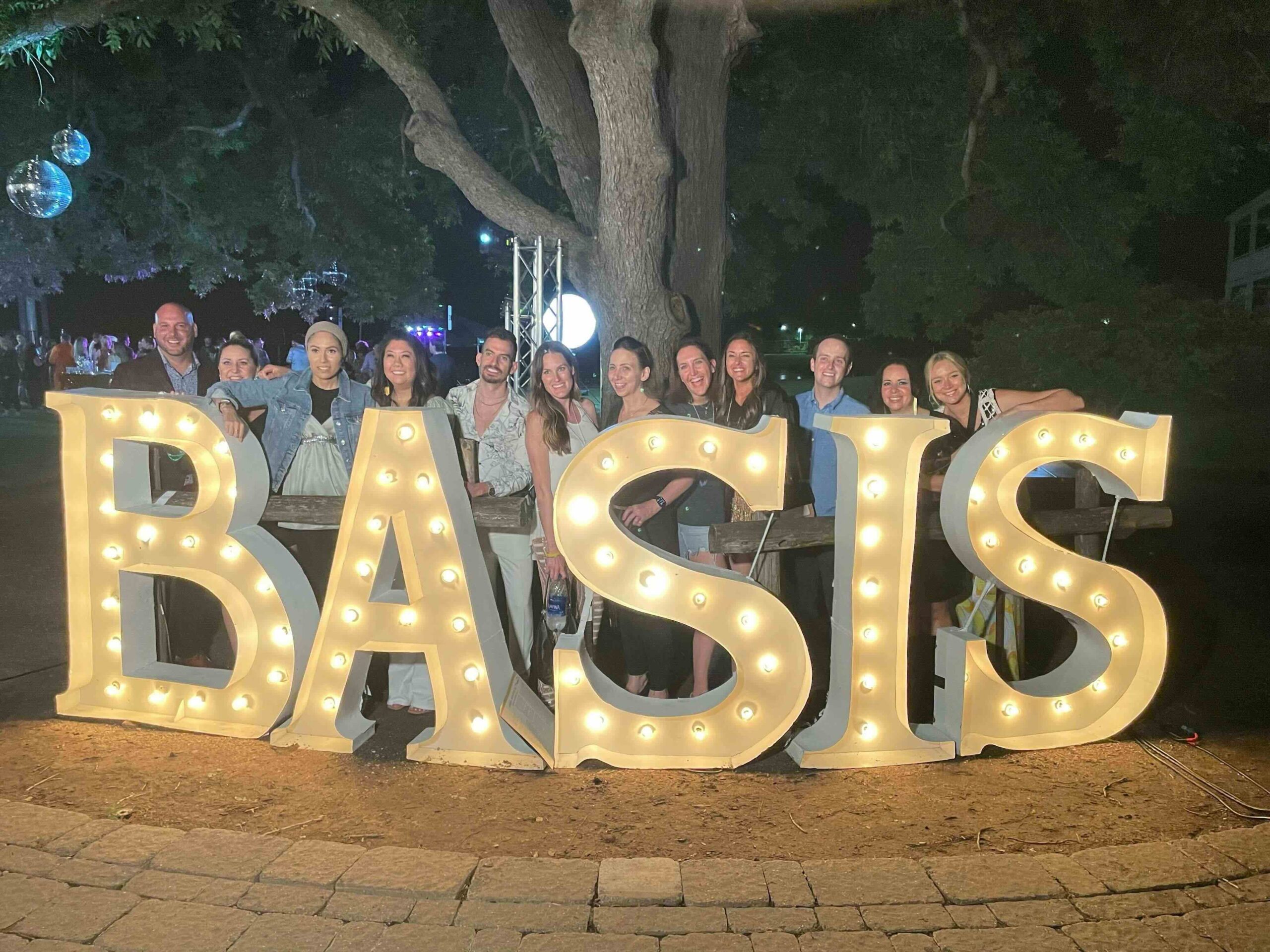basis employees standing in front of basis sign at company event