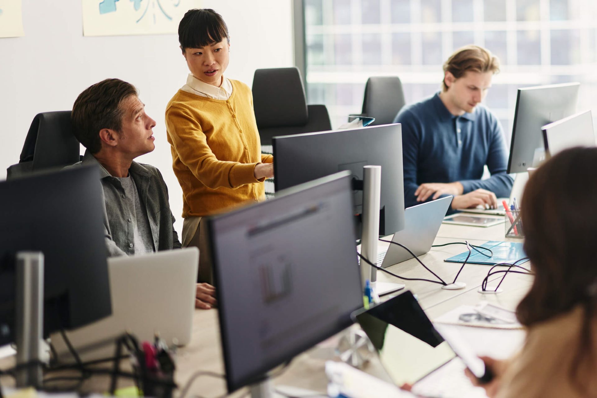 Advertisers at an agency huddle around a computer in the office