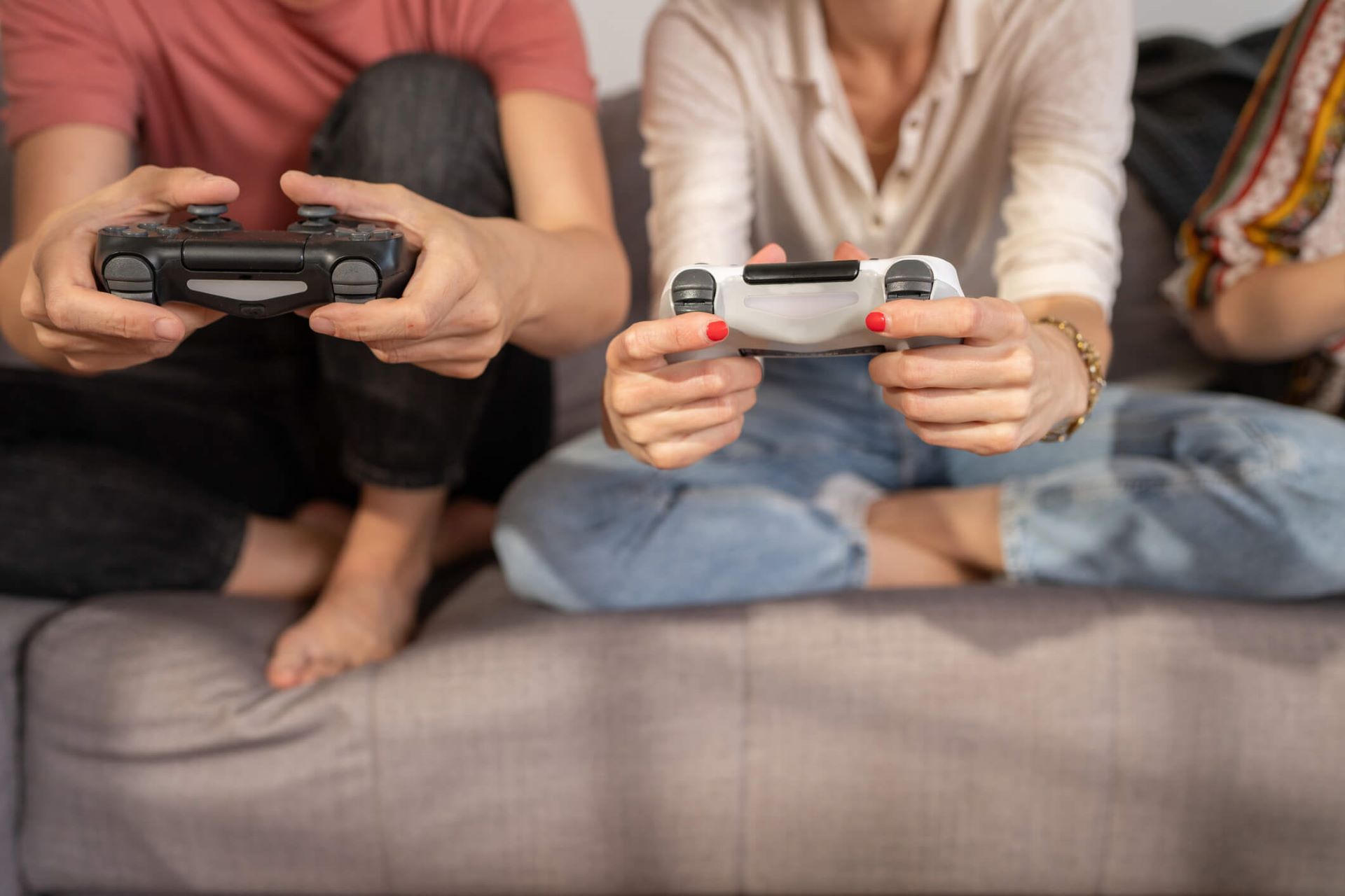 An image of several young people sitting on a couch while gaming