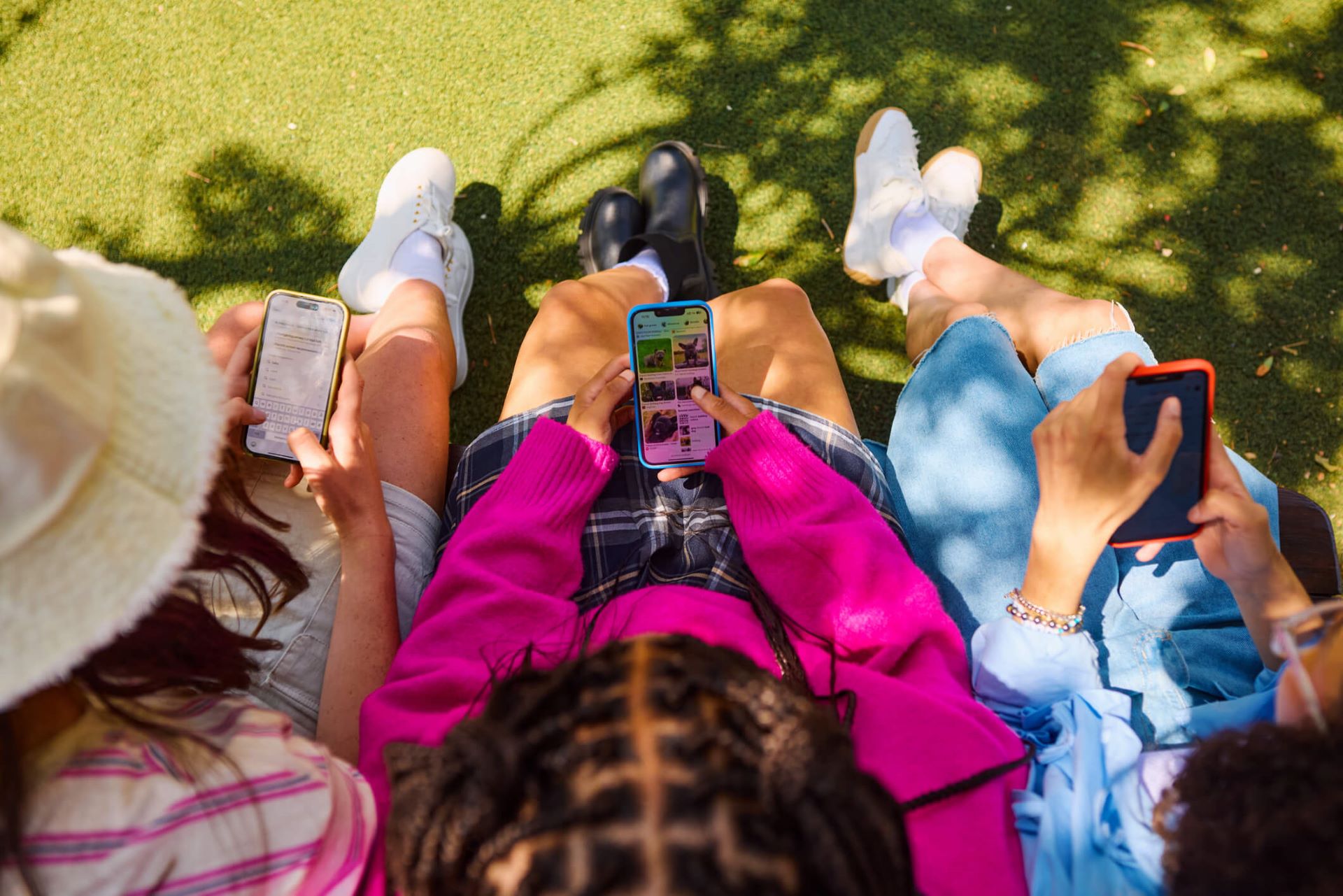 An image showing three people scrolling on their smartphones