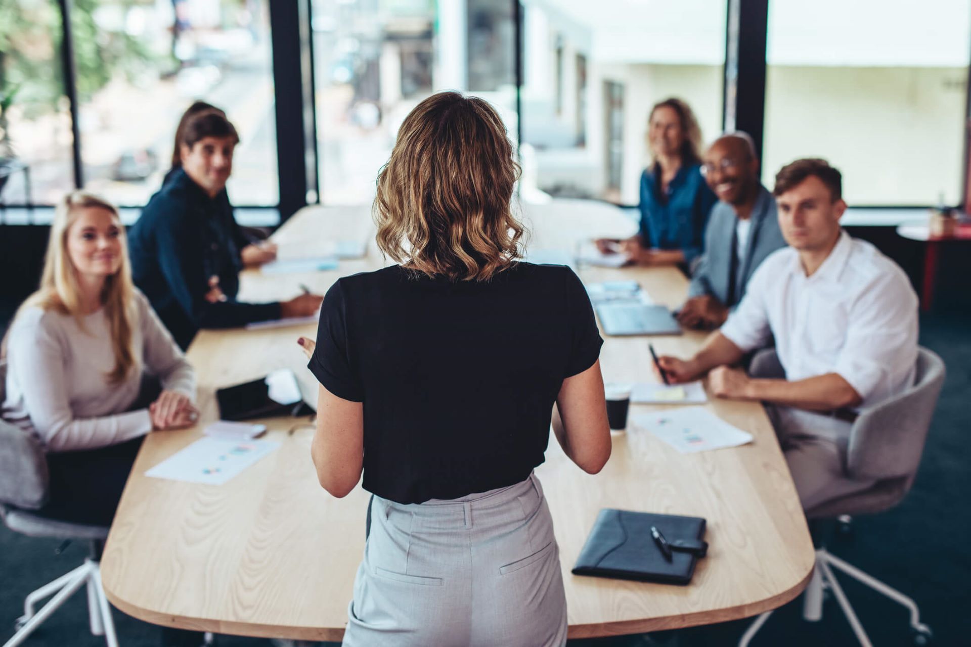 An image showing a marketing presenting in front of other c-suite executives