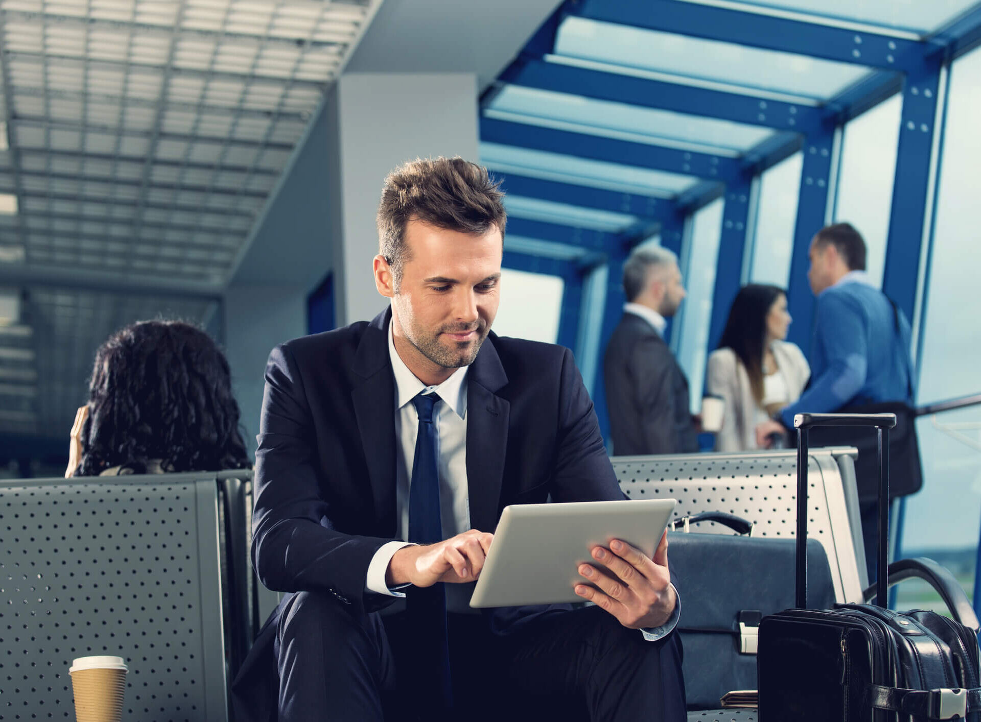 Businessman reading on his tablet in an airport