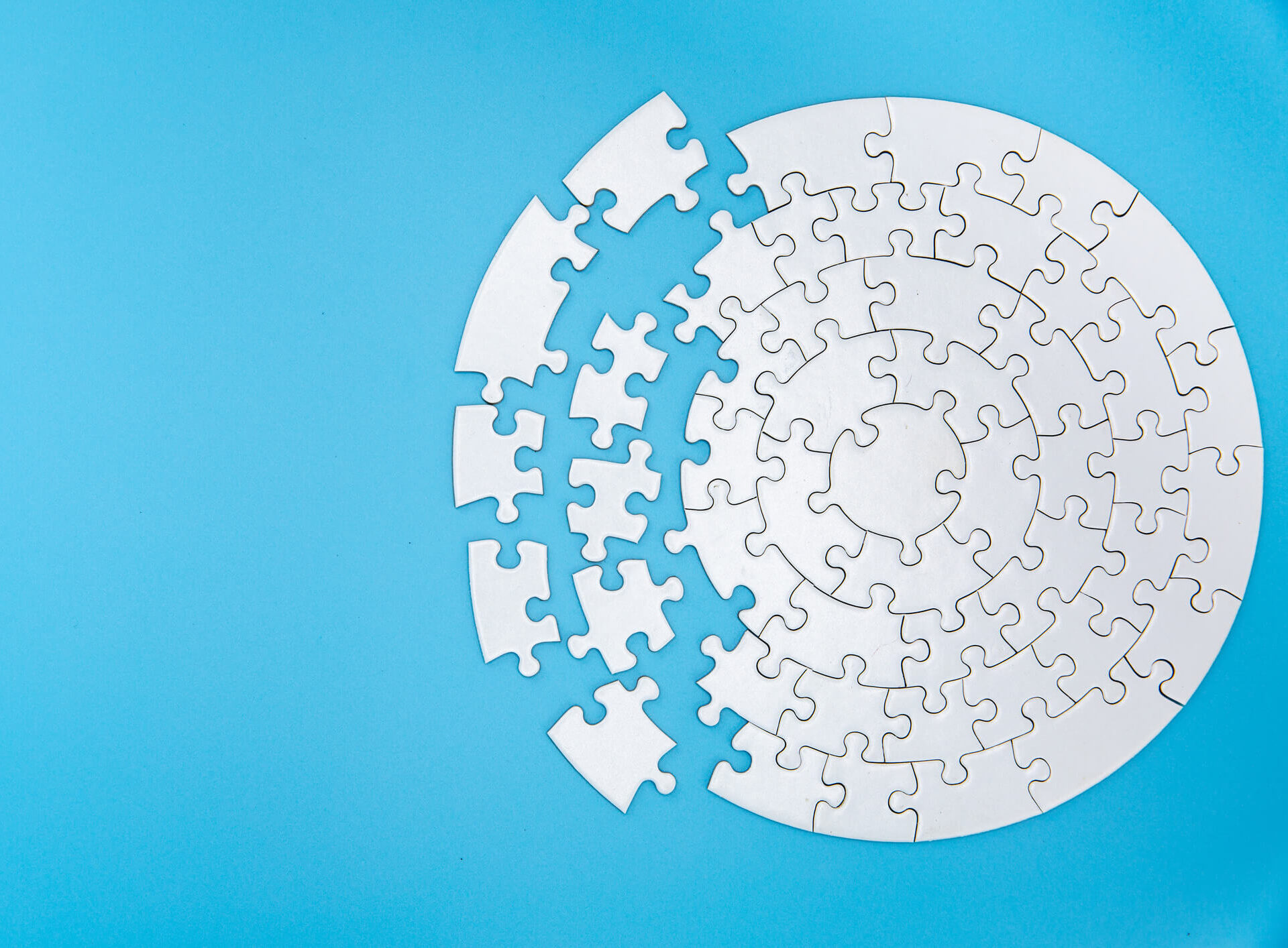 Puzzle pieces coming together to form a circle