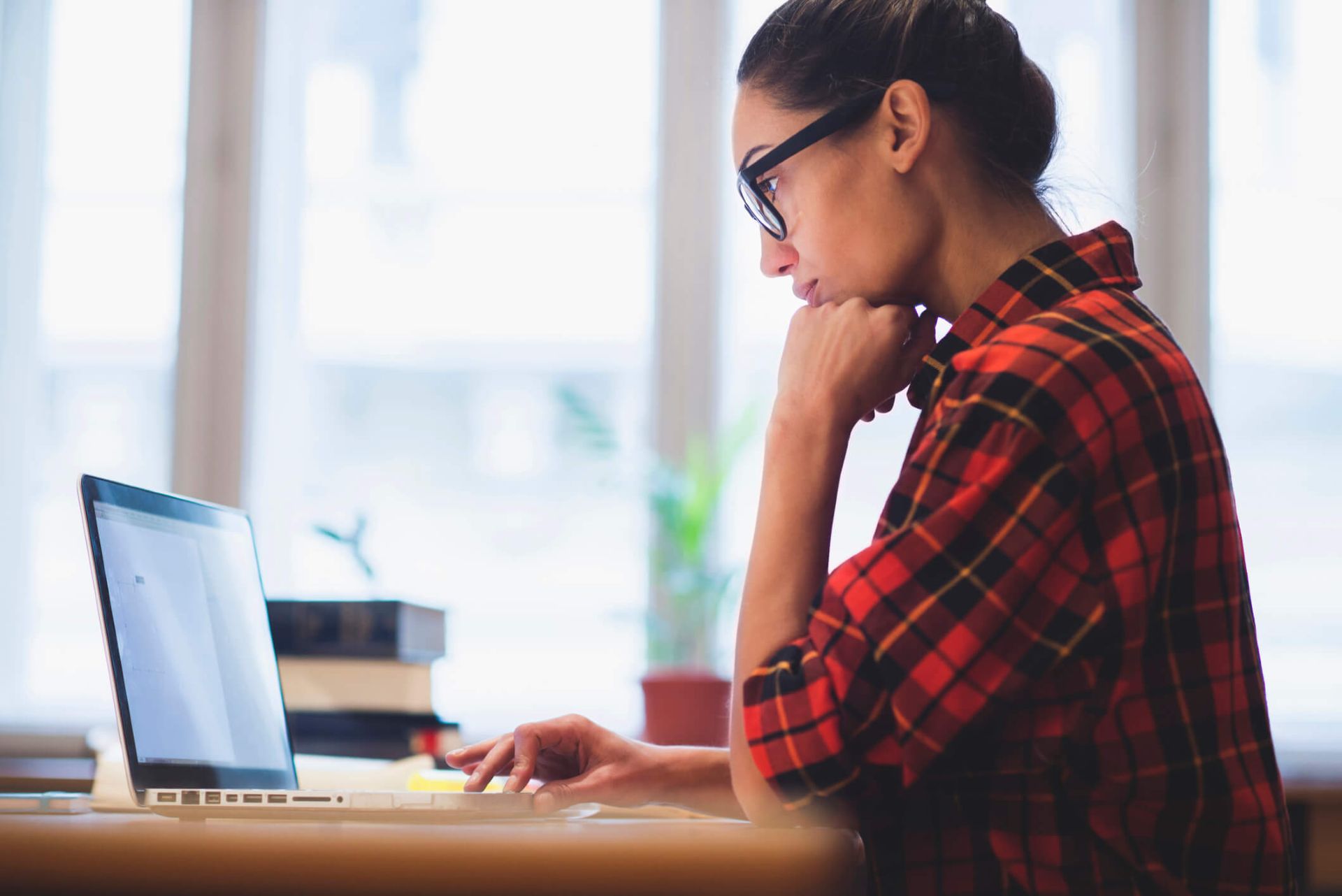 An image of a woman sitting at a laptop searching for something online