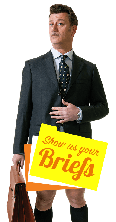 Man in a suit with a sign over his lower half that says Show Us Your Briefs