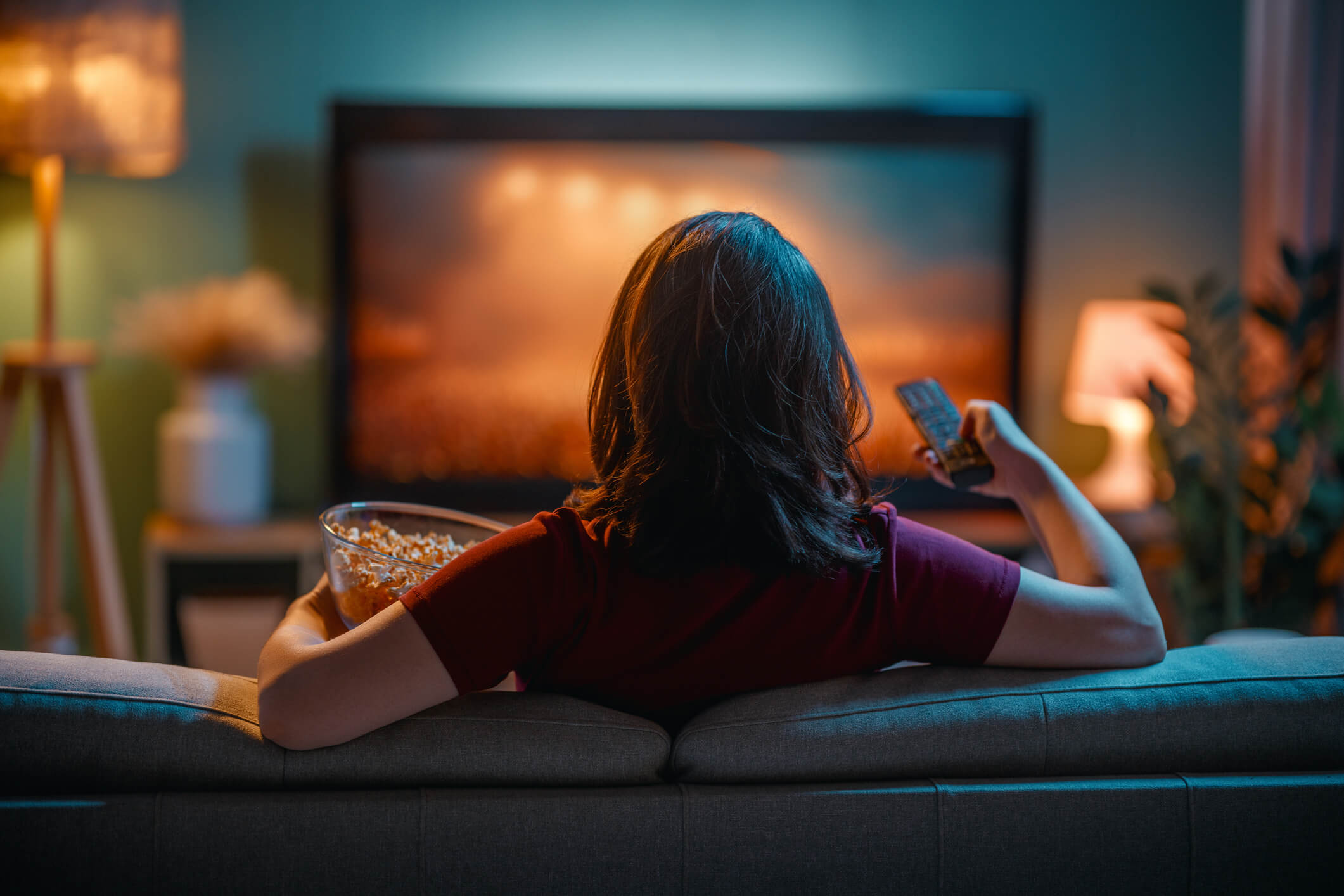 Woman watching TV with a bowl of popcorn